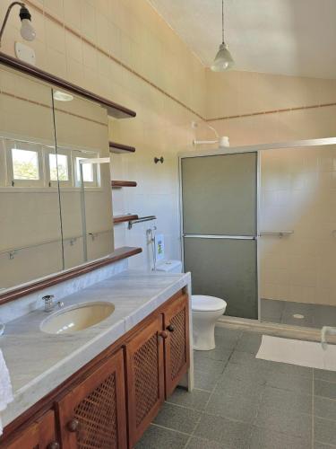 a bathroom with a sink and a toilet and a mirror at Casa Beira-Mar em Guadalupe in Sirinhaém