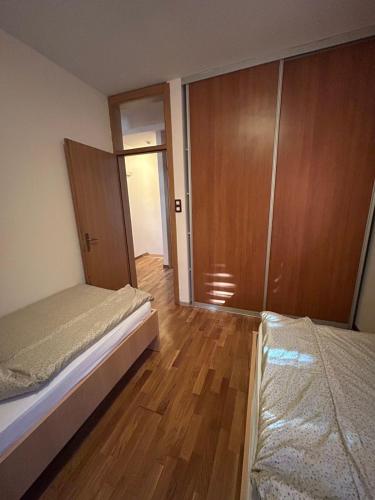 a bedroom with two beds and a wooden floor at Premium Apartment in Fojnica
