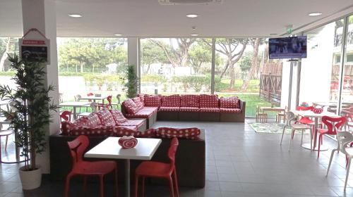 a lobby with couches and tables and chairs and a television at Parque De Campismo Orbitur Guincho in Cascais