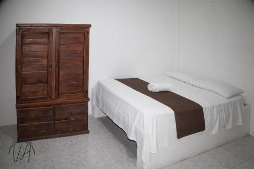 a bedroom with a bed and a wooden dresser at Villa Alfredo in Veracruz