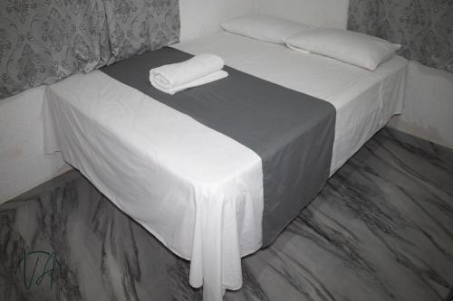 a white bed with two white towels on it at Villa Alfredo in Veracruz