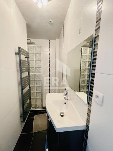 une salle de bain avec un lavabo blanc et un miroir dans l'établissement Chambre chez l'habitant ou Homestay dans le quartier de BONHOURE, à Toulouse