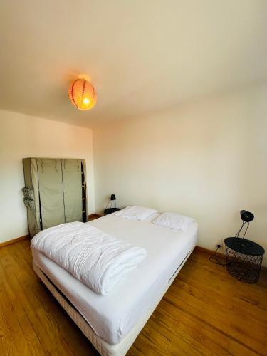 - une chambre avec un lit blanc et une lumière au plafond dans l'établissement Chambre chez l'habitant ou Homestay dans le quartier de BONHOURE, à Toulouse