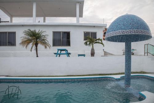 a house with a swimming pool with a blue sphere in the water at Villa Alfredo in Veracruz