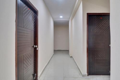 an empty hallway with a wooden door and a room at Hotel O Shri Ganesh Near By Himayatnagar,Ashok Nagar,RTC X Roads in Hyderabad