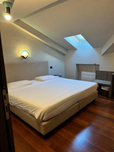a bedroom with a large white bed with a skylight at Jet Hotel in Caselle Torinese