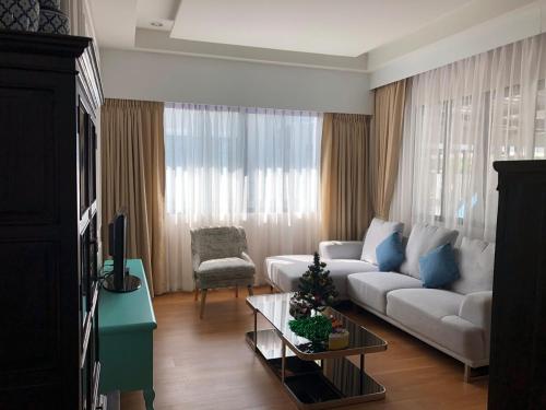 a living room with a white couch and blue pillows at Villa Siri 49 Luxury 4 BR Chiang Mai in Chiang Mai