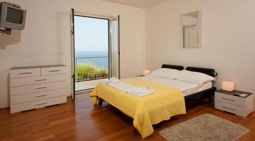 a bedroom with a bed and a large window at Villa Apartments Mecajac in Cavtat