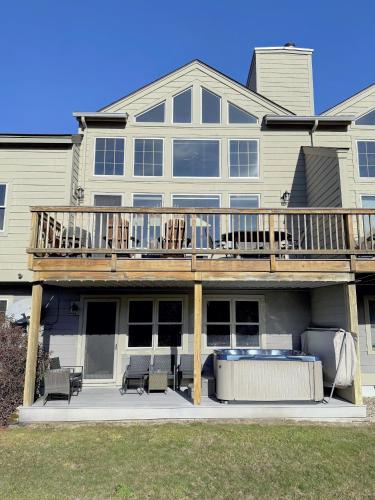 a large house with a deck and a hot tub at H4 Ski Slope Views! Bretton Woods condo with easy access to Mt Washington, Skiing, White Mountains! in Carroll