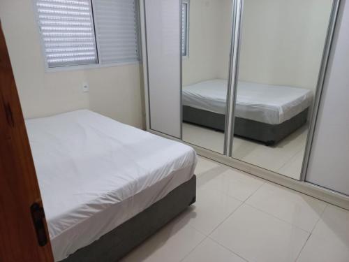 ein Zimmer mit zwei Betten und einem Spiegel in der Unterkunft Casa no Resort - Aguas de Santa Barbara in Águas de Santa Barbara