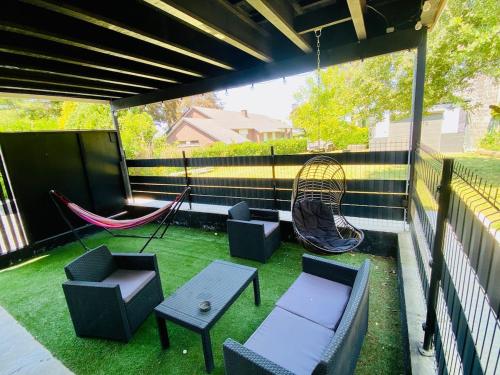 a patio with a hammock and chairs and a swing at Loft de Waroux in Awans