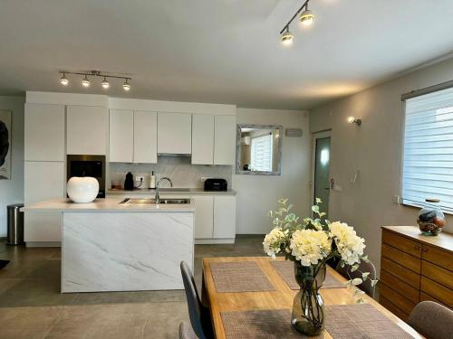 a kitchen with a table and a kitchen with white cabinets at Loft de Waroux in Awans