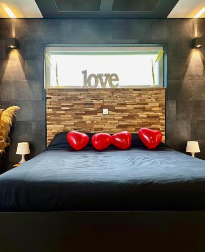 a bedroom with red pillows on a bed with a window at Loft de Waroux in Awans