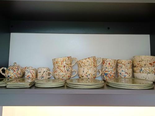a bunch of cups and plates on a shelf at Bosque Cipreses Sur in San Carlos de Bariloche