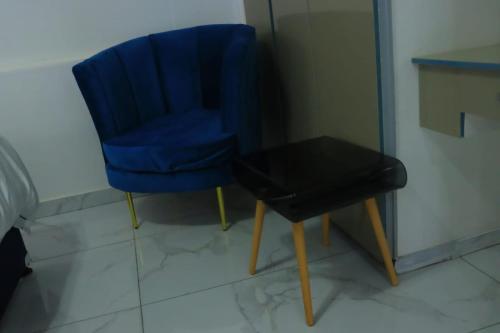 a blue chair and a table in a room at Musina Crown Guest House in Musina