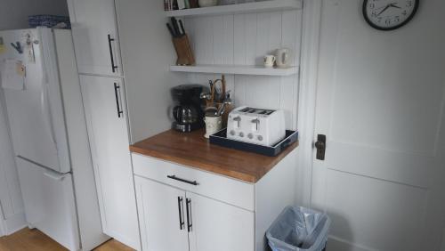 a kitchen with white cabinets and a toaster on a counter at The Pelton House in New Buffalo