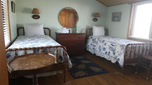 a bedroom with two beds and a dresser and a mirror at The Pelton House in New Buffalo