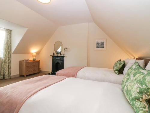 a bedroom with two beds and a mirror at Harmony Cottage - Harmony Gardens in Melrose