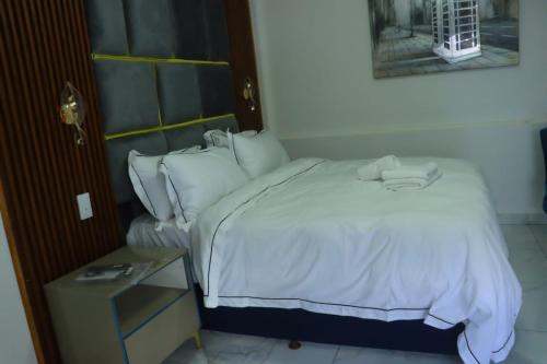 a bedroom with a white bed with a phone on it at Musina Crown Guest House in Musina
