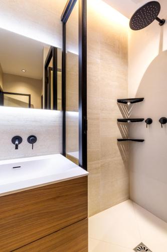 une salle de bain avec un lavabo blanc et un miroir dans l'établissement Montmorency - Studio unique, à Paris