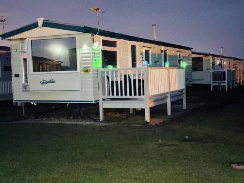 a large white house with a porch at night at Golden Sands Holiday Home in Skegness