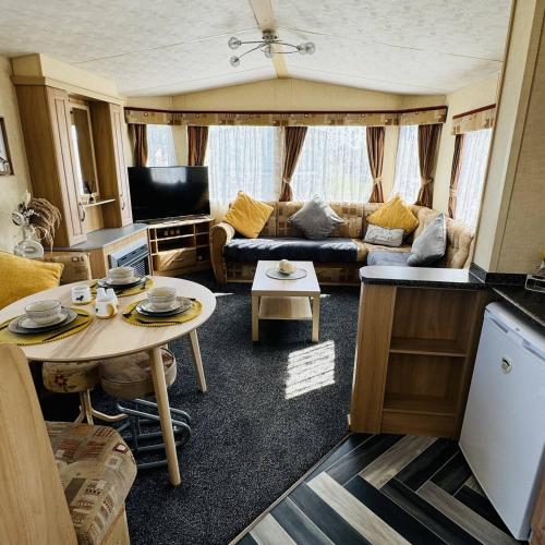 a living room with a couch and a table at Summer Dreams Holiday Home Skegness in Skegness