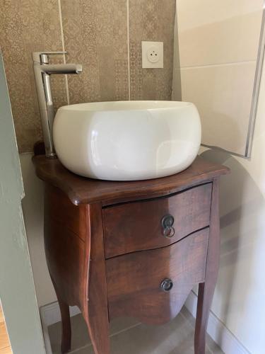 a sink on top of a wooden dresser in a bathroom at La Jarria in Jurançon