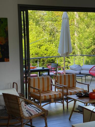 - un salon avec des chaises et un parasol dans l'établissement Villa Bella à Arcachon, à Arcachon