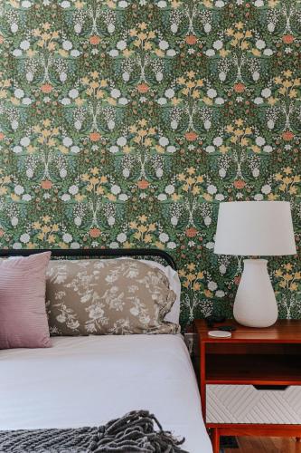 a bedroom with a bed with a floral wallpaper at Modern Cabin on 26 acres,Hot Tub,Fire Pit,GameRoom in Berkeley Springs