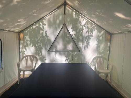 a dining room table with two chairs and a wall with trees at Slumberland at the River's Edge in Pond Eddy