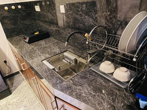 a kitchen counter with a sink and a drying rack at Little Villa in Habaraduwa