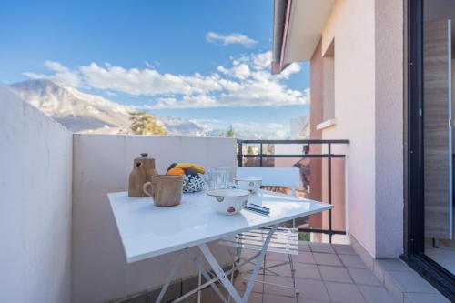 - une table blanche sur un balcon avec vue sur les montagnes dans l'établissement Cozy studio, very close to Lake Annecy, à Annecy