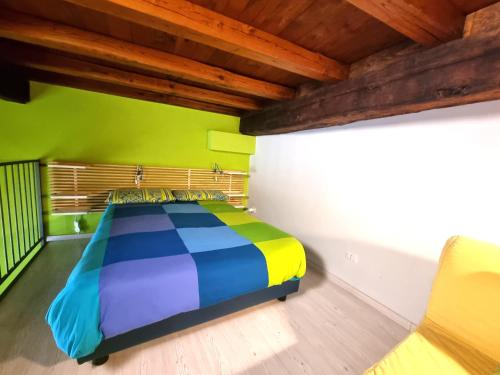 a colorful bed in a room with a wooden ceiling at H2 Via Saffi in Viterbo