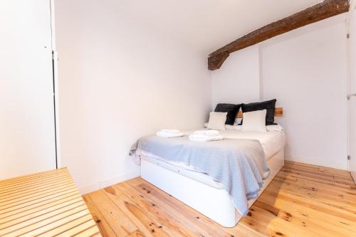 a white bedroom with a bed and a wooden floor at Warm and Inviting, Central location by urbanhosting in Santander