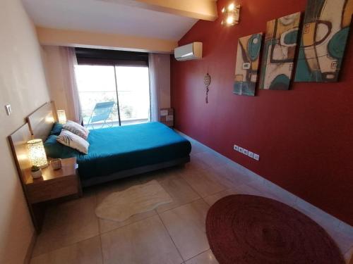 une chambre avec un lit bleu et une fenêtre dans l'établissement T3 Independant de 62 m2 au coeur du village, à Saint-Georges-dʼOrques