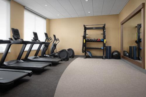a gym with a row of tread machines in a room at Hilton Garden Inn Denver Airport Tower Road in Denver
