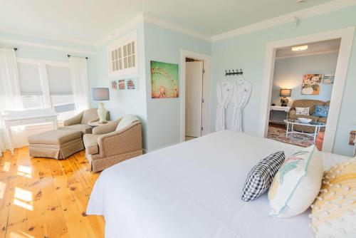 a white bedroom with a bed and a living room at Ocean House Boutique Hotel & Motel in Old Orchard Beach