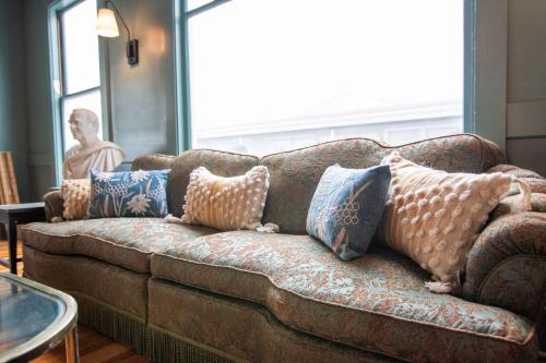 a couch with pillows on it in a living room at Ocean House Boutique Hotel & Motel in Old Orchard Beach