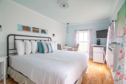 a bedroom with a large white bed and a kitchen at Ocean House Boutique Hotel & Motel in Old Orchard Beach
