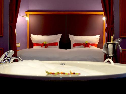 a bedroom with a bed and a bath tub and a sink at Hotel BEI SCHUMANN in Kirschau