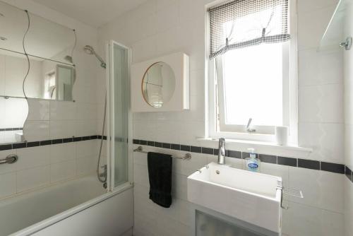 a white bathroom with a sink and a mirror at 4guests-2br-privategarden-freeparking in Aviemore