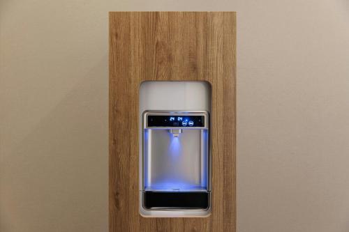 a cell phone is sitting on a wooden wall at Four Points Flex by Sheraton Yokohama West in Yokohama
