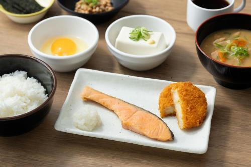 a table with a plate of food with sushi and rice at Four Points Flex by Sheraton Yokohama West in Yokohama