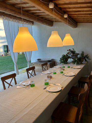 a large wooden table with chairs and lights at Agriturismo Bibiano38 in Treia