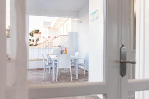 a dining room with a white table and chairs at Villa N in Torre Suda