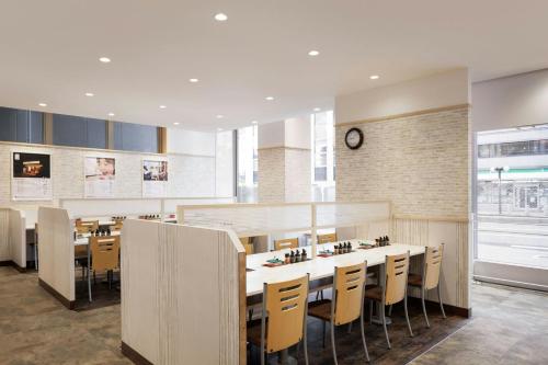 a restaurant with a table and chairs and a clock at Four Points Flex by Sheraton Kobe Sannomiya in Kobe