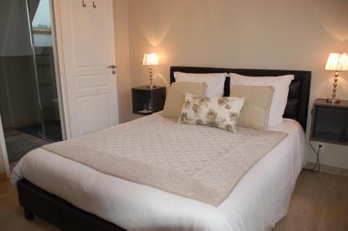a bedroom with a large bed with white sheets and pillows at L'Alidade Chambres d'hôtes in Wimereux
