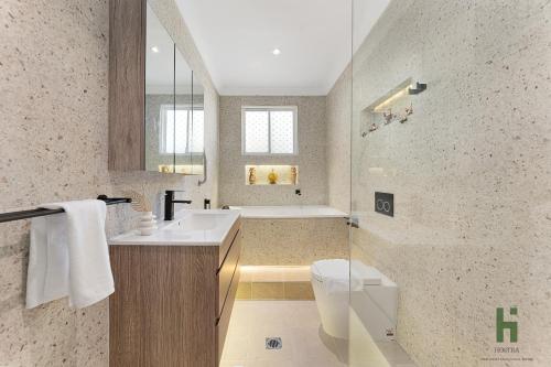 a bathroom with a tub and a sink and a toilet at edgeware house in Sydney