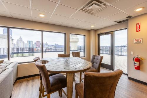 a dining room with a table and chairs and windows at King Bed - Heart of PB - Jaw-Dropping Rooftop and Gym in Pittsburgh
