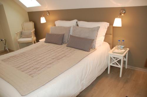 a bedroom with a large white bed with a side table at L'Alidade Chambres d'hôtes in Wimereux